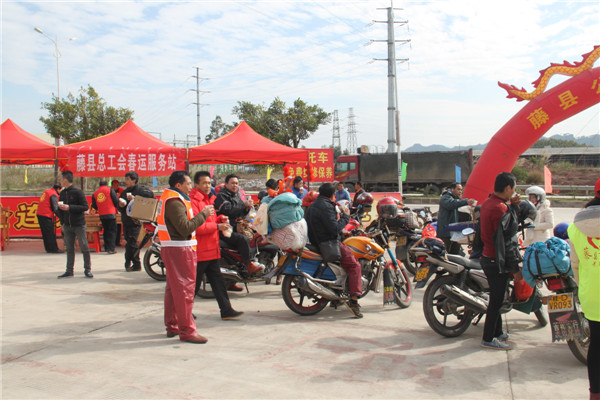圖為藤縣總工會在省道304線藤縣陶瓷工業(yè)園區(qū)商業(yè)街小廣場設(shè)立藤縣總工會為農(nóng)民工平安返鄉(xiāng)“暖流行動”服務(wù)站，積極為騎摩托車